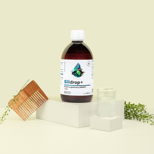Butelka z etykietą Silidrop-krzem-organiczny-MMST-bor-plyn-500-ml_1500x1500 jest pokazana obok drewnianego grzebienia, zlewki z przezroczystym płynem i zielonych gałązek roślin na jasnym tle.